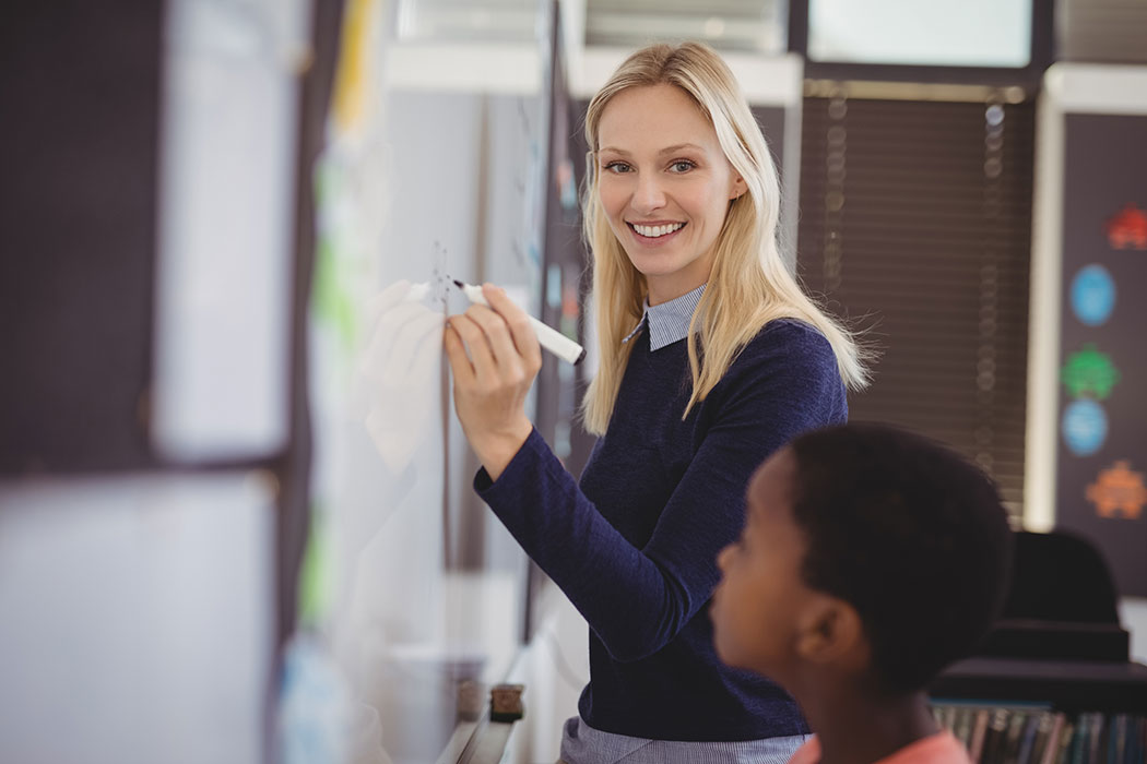 Teacher with student at chalkboard